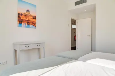 a white bedroom with a bed and a picture on the wall at Villa Nogueira V with Private Pool by Holiday Rental Madeira in Funchal