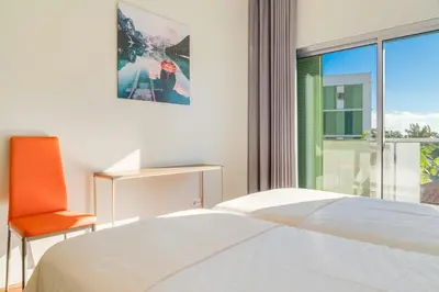 a bedroom with a bed and a chair and a window at Villa Nogueira V with Private Pool by Holiday Rental Madeira in Funchal