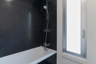 a bathroom with a shower with a white bath tub at Villa Nogueira V with Private Pool by Holiday Rental Madeira in Funchal