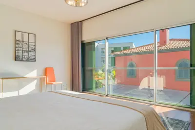 a bedroom with a bed and a large window at Villa Nogueira V with Private Pool by Holiday Rental Madeira in Funchal