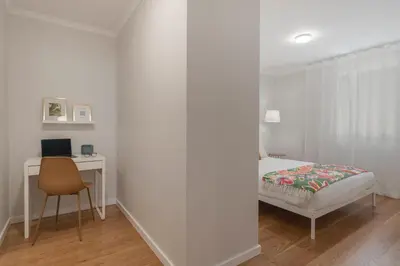 a bedroom with a bed and a desk and a chair at Solar da Fontinha by An Island Apart in Santa Cruz
