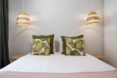 a bedroom with a white bed with two pillows at Solar da Fontinha by An Island Apart in Santa Cruz