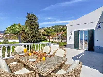 a patio with a table and chairs on a balcony at Avocado Villa by LovelyStay in Funchal