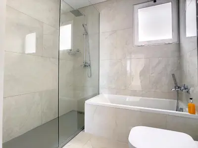 a bathroom with a shower and a tub and a toilet at Avocado Villa by LovelyStay in Funchal