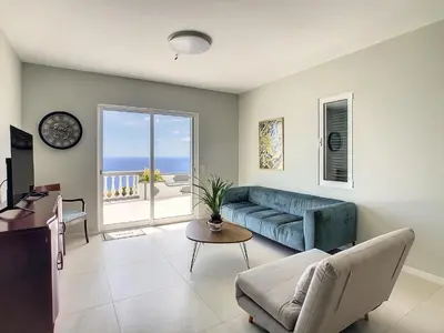 a living room with a blue couch and a table at Avocado Villa by LovelyStay in Funchal