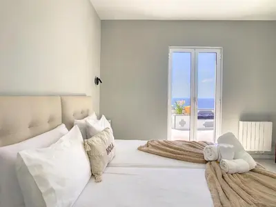 a bedroom with a white bed with a view of the ocean at Avocado Villa by LovelyStay in Funchal
