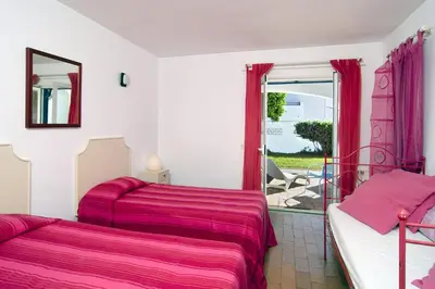 a bedroom with two beds and a window with a patio at 602 Casa Alma Mar in Luz