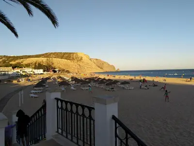 a beach with chairs and umbrellas and people on the beach at 602 Casa Alma Mar in Luz
