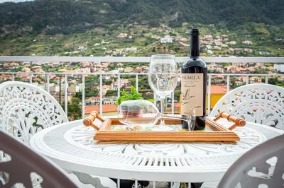 a table with a bottle of wine and a glass at Casa da Avó in Machico