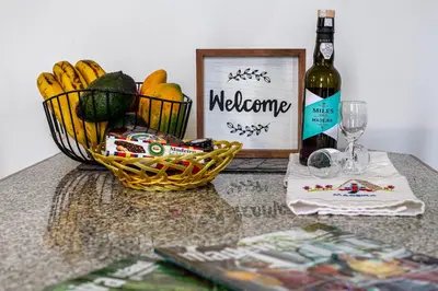 a table with a basket of fruit and a bottle of wine at Casa da Avó in Machico