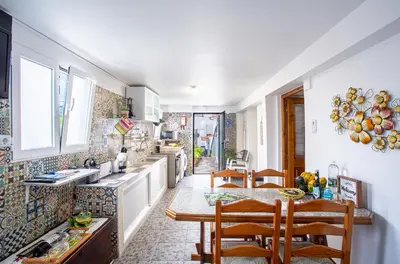 a kitchen with a table and some chairs in it at Casa da Avó in Machico