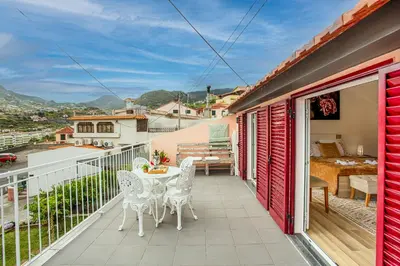 a patio with a table and chairs on a balcony at Casa da Avó in Machico