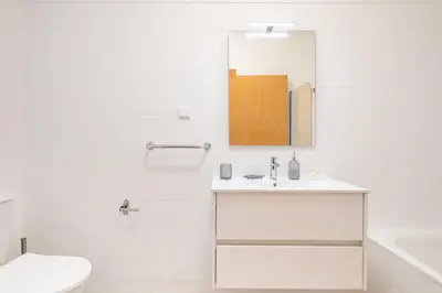 a white bathroom with a sink and a mirror at Apartamento Centralis by Homie in Funchal