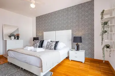 a bedroom with a white bed and a gray accent wall at Apartamento Centralis by Homie in Funchal