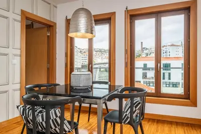 a dining room with a table and chairs and a window at Apartamento Centralis by Homie in Funchal