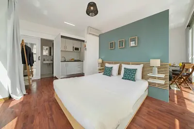 a bedroom with a large white bed with a blue wall at Pelourinho Apartments by An Island Apart in Funchal
