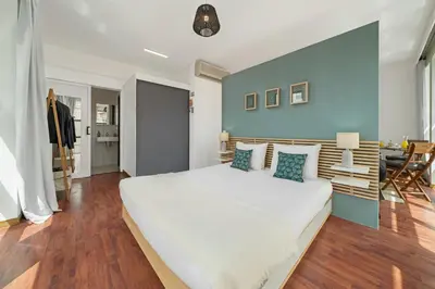 a bedroom with a large white bed and a blue wall at Pelourinho Apartments by An Island Apart in Funchal