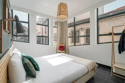 a bedroom with a white bed and windows at Pelourinho Apartments by An Island Apart in Funchal