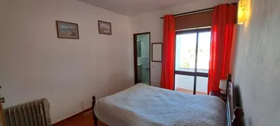 a bedroom with a bed and a window with red curtains at Seaview Apartment 100m from beach in Luz