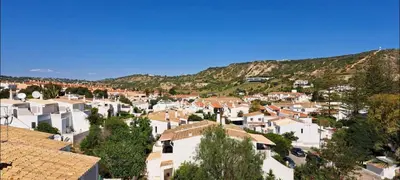 a village with houses and mountains in the background at Seaview Apartment 100m from beach in Luz
