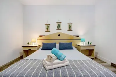 a bedroom with a large bed with blue pillows at Funchal Boa Nova Apartment in Funchal