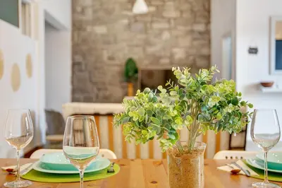 a table with two wine glasses and a plant on it at Funchal Boa Nova Apartment in Funchal