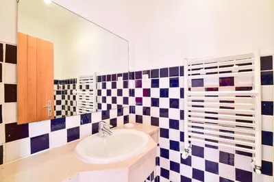 a bathroom with a sink and a checkered wall at Apartment Luz Views by MOJE Holiday in Luz
