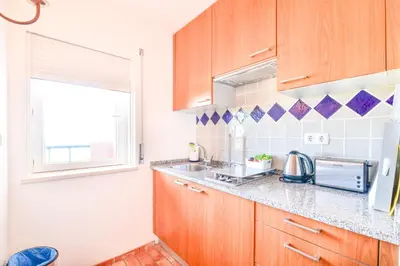 a kitchen with wooden cabinets and a sink and a window at Apartment Luz Views by MOJE Holiday in Luz