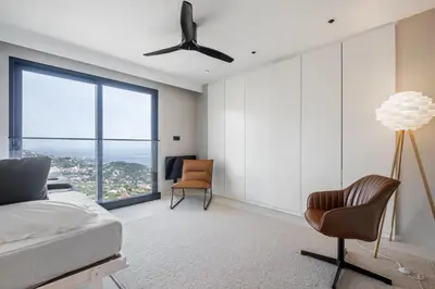 a bedroom with a bed and a chair and a window at House of Cork and Ivy - By WeHost in Câmara de Lobos