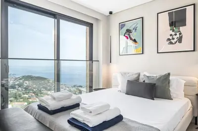 a bedroom with a white bed with a large window at House of Cork and Ivy - By WeHost in Câmara de Lobos