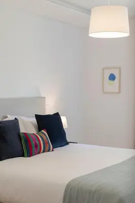 a bedroom with a white bed with pillows at CASA DO MIRADOURO 6 by Heart of Funchal in Funchal