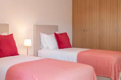 two beds in a hotel room with red pillows at CASA DO MIRADOURO 6 by Heart of Funchal in Funchal