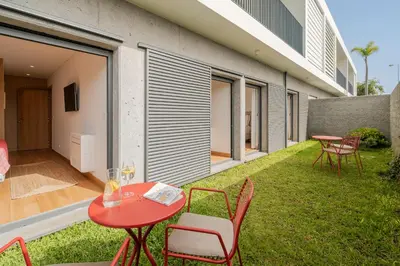 a patio with a red table and chairs on the grass at CASA DO MIRADOURO 6 by Heart of Funchal in Funchal