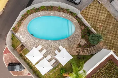 an overhead view of a swimming pool with white umbrellas at CASA DO MIRADOURO 5 by Heart of Funchal in Funchal