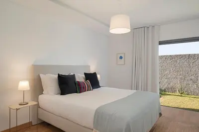 a bedroom with a white bed and a window at CASA DO MIRADOURO 7 by Heart of Funchal in Funchal