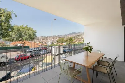 a balcony with a table and chairs and a view of a street at CASA DO MIRADOURO 7 by Heart of Funchal in Funchal