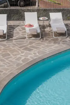 two chairs and a swimming pool with chairs and a table at CASA DO MIRADOURO 7 by Heart of Funchal in Funchal