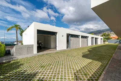 a white house with a green yard at CASA DO MIRADOURO 7 by Heart of Funchal in Funchal