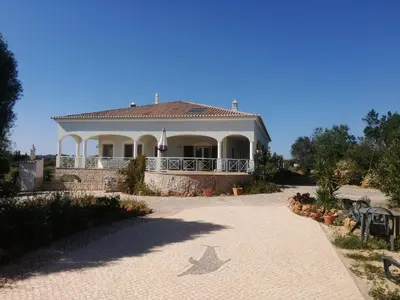 a large white house with a porch and a driveway at Chambres Guest house in Bensafrim