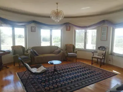 a living room with a couch and chairs and windows at Chambres Guest house in Bensafrim