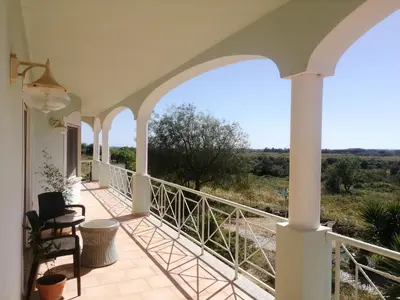 a house with a balcony with a view at Chambres Guest house in Bensafrim
