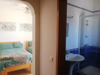 a bathroom with a bed and a sink and a shower at Chambres Guest house in Bensafrim