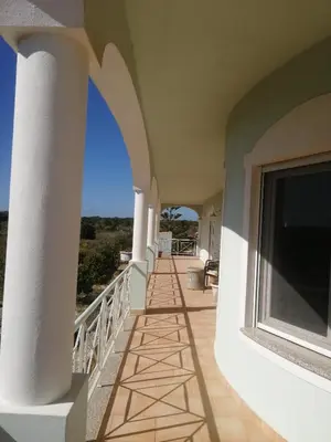 a balcony of a house with a view of the ocean at Chambres Guest house in Bensafrim