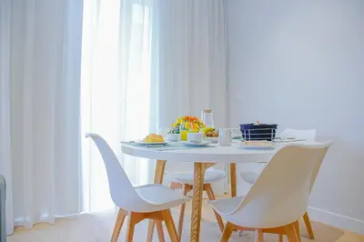 a white dining room table with white chairs at Casal da Penha Apartments in Funchal
