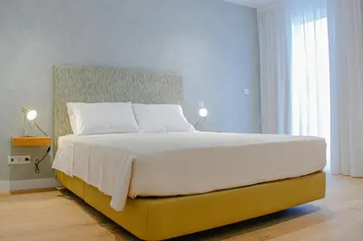 a bedroom with a large white bed with two lamps at Casal da Penha Apartments in Funchal