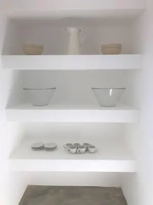 a white shelf with bowls and shoes on it at Casa 70 - Surfboard included in Aljezur