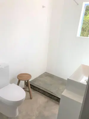 a white bathroom with a toilet and a stool at Casa 70 - Surfboard included in Aljezur