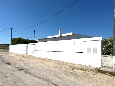 a white wall on the side of a dirt road at Casa 70 - Surfboard included in Aljezur