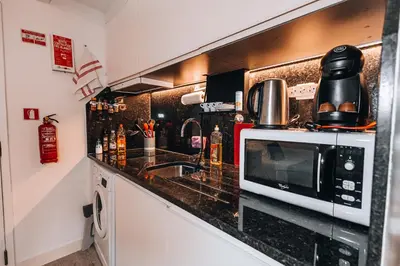 a kitchen with a microwave and a sink at Casa Branca Apartments by TrIp2Portugal in Funchal