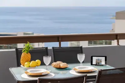 a table with a plate of food on a balcony at Casa Branca Apartments by TrIp2Portugal in Funchal